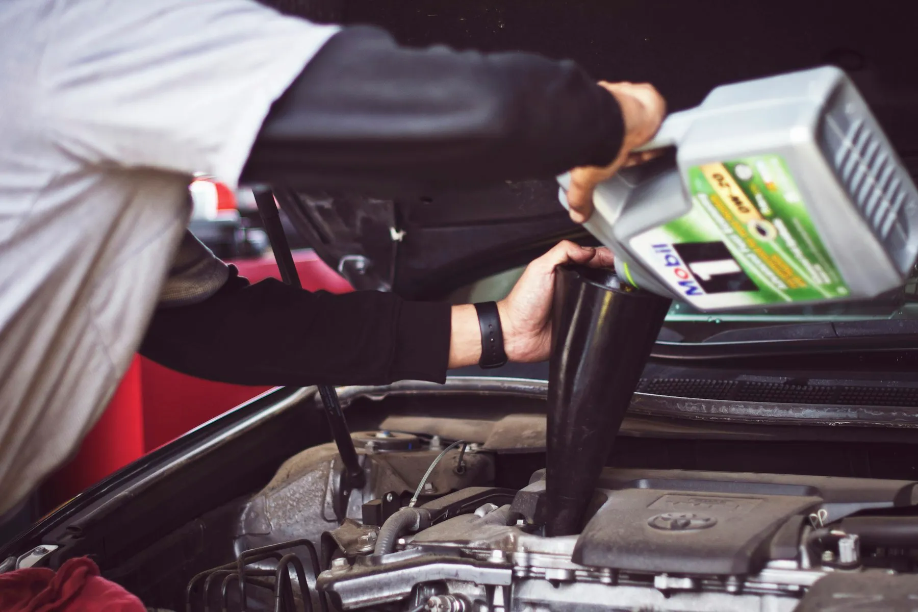 Technician working under the hood of a vehicle